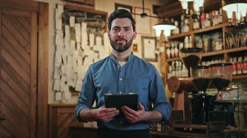 Man Holding Tablet Smiling in Coffee Shop