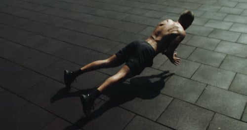 Fit Man Doing Pushups Outdoors in Urban Setting