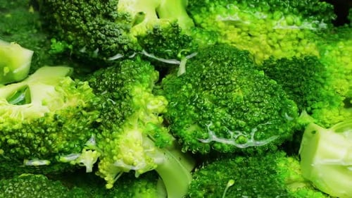 Bright green broccoli florets in a pot of boiling water.