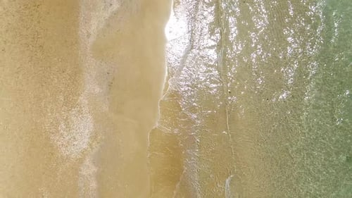 Aerial footage of Tropical Sandy beach with waves breaking on shore