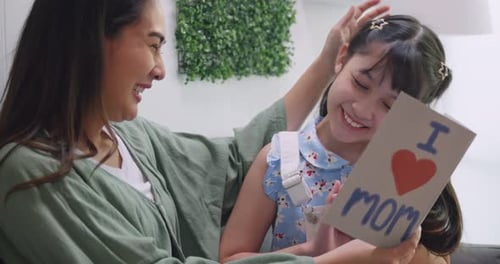 Young Girl Gives Mother Birthday Card With Love