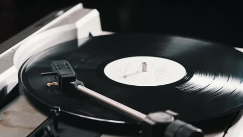 Turntable Needle Drop on a Spinning Vinyl Record to Playing Music Close Up