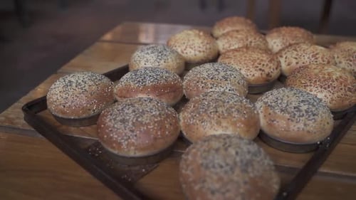 Close up shot of delicious homemade burger bread with seeds on wooden table.