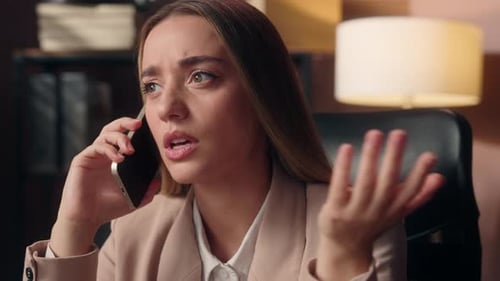 Upset Woman Talking on Phone in Office
