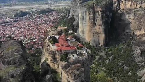 A monastery built on a rock formation towers above a valley