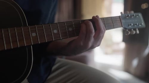 Close up of a Man's hand hand playing an acoustic guitar