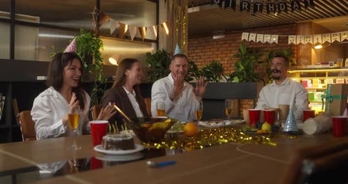 Happy Group of Office Workers in Business Suits Sitting at the Table and Dancing During a Happy