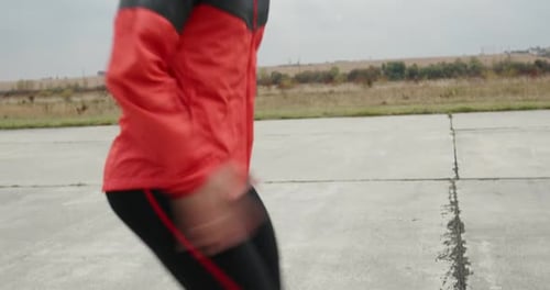 Man Jogging in Red Jacket on Rural Road