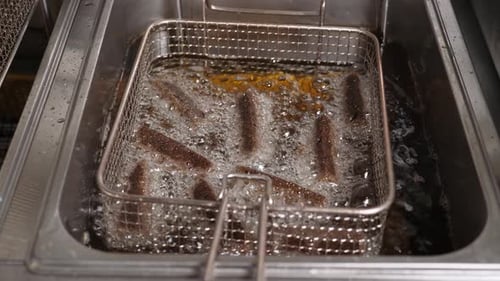 Closeup of Sliced Black Bread Fried in Boiling Oil Deepfried in the Kitchen