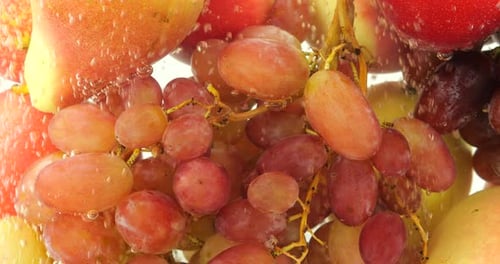 Background with fruits and berries in water with air bubbles.