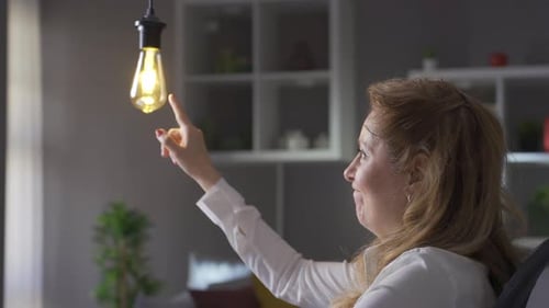 Idea lamp. Mature business woman thinks about idea and idea lamp flashes.