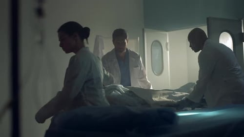 Ärzte bringen Patienten nach erfolgreicher chirurgischer Behandlung in eine dunkle Krankenhausstation. Multikulturell