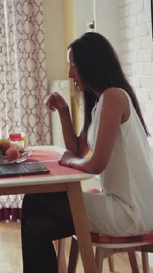Young Adult Woman Using Laptop at Home