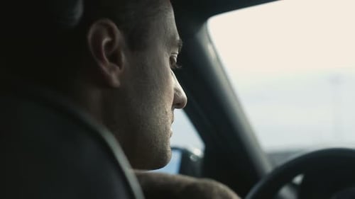 Man talking on smartphone while driving in car