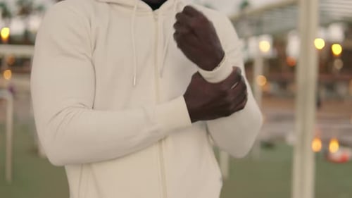 Adult Adjusts Jacket Sleeves While Outside