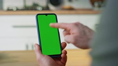 Hand Pointing Smartphone Green Screen Browsing Application in Apartment Closeup