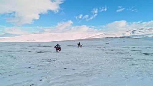 People Riding Horses in Winter Landscape