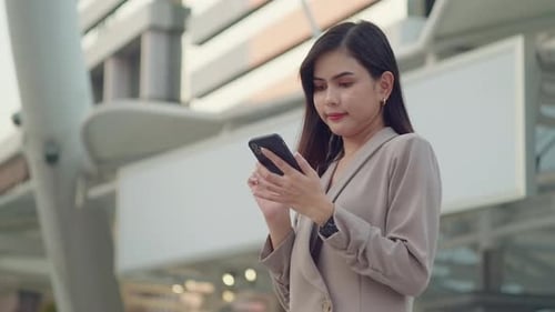 A young beautiful businesswoman is using Smart phone in Modern city