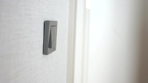Finger Turning Off Light Switch in Home