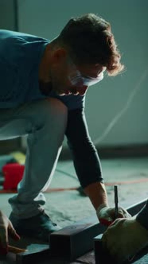 Focused Craftsman Working Meticulously on Metal Fabrication Shaping and Measuring Components with