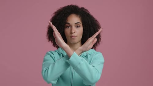 Mujer con cabello castaño rizado cruzando las manos