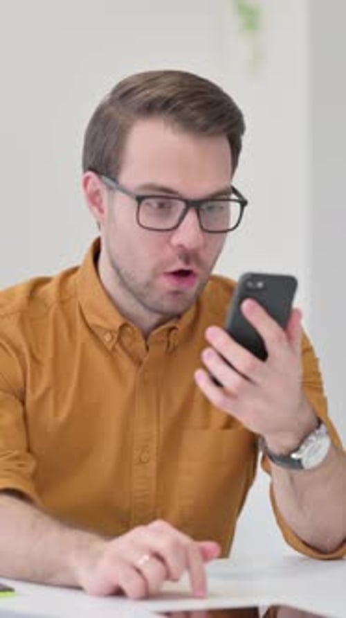 Excited Man Reacting to Good News on Smartphone