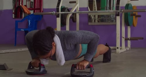 Sexy fitness girl performing push ups at the gym low angle shot