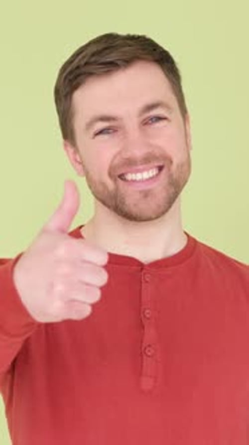The Australian Gives a Thumbs Up in Agreement Handsome Man on a Green Background Vertical Video