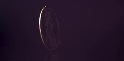 Gold Coin Spinning on Reflective Surface in Studio