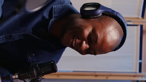 Adult Wearing Headphones Speaking Into Microphone in Vertical Video