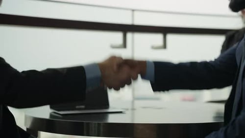 Business Handshake After Successful Meeting in Bright Office