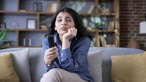 Bored Woman Holding Remote Control on Couch