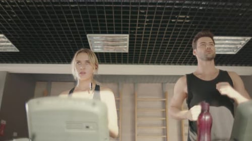 Sport Couple Training Run on Treadmill Machine in Fitness Club. Handsome Man
