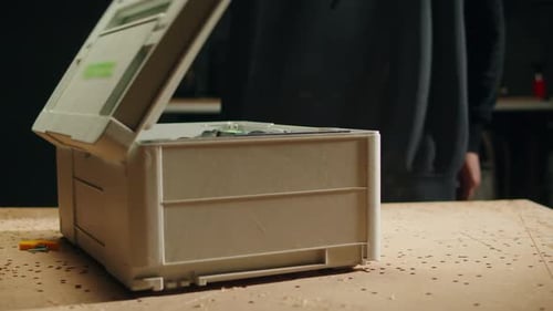 Person Attaches Bit to Electric Drill from Toolbox