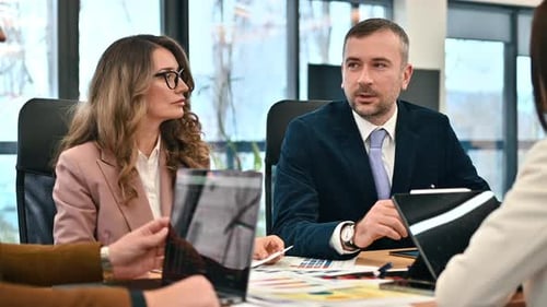 Team leader leading a business meeting in an office, workers discussing business affairs. Gadgets an