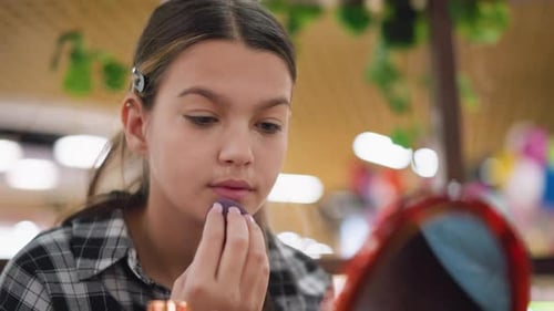 Closeup View of Young Girl Perfecting Makeup on Jaw