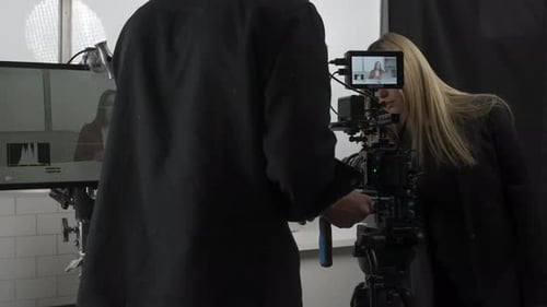 Woman Advising Camera Operator in Studio Setting