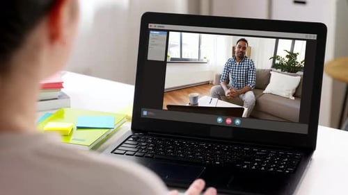 Frau benutzt Laptop für Videoanrufe mit einem indischen Mann während der Coronavirus-Pandemie