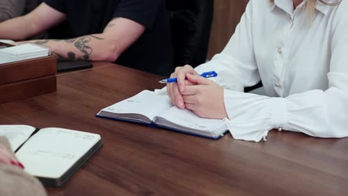 Team Meeting at a Conference Table with Notebooks