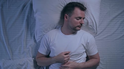 Man Sleeping Peacefully in Bed at Night