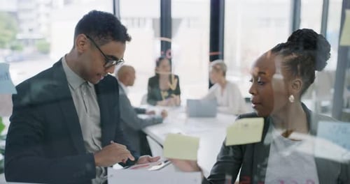 4k video footage of two businesspeople brainstorming with notes a glass wall in an office