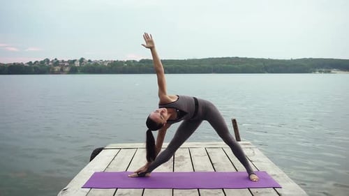 Fit Woman Stretching on Wooden Pier