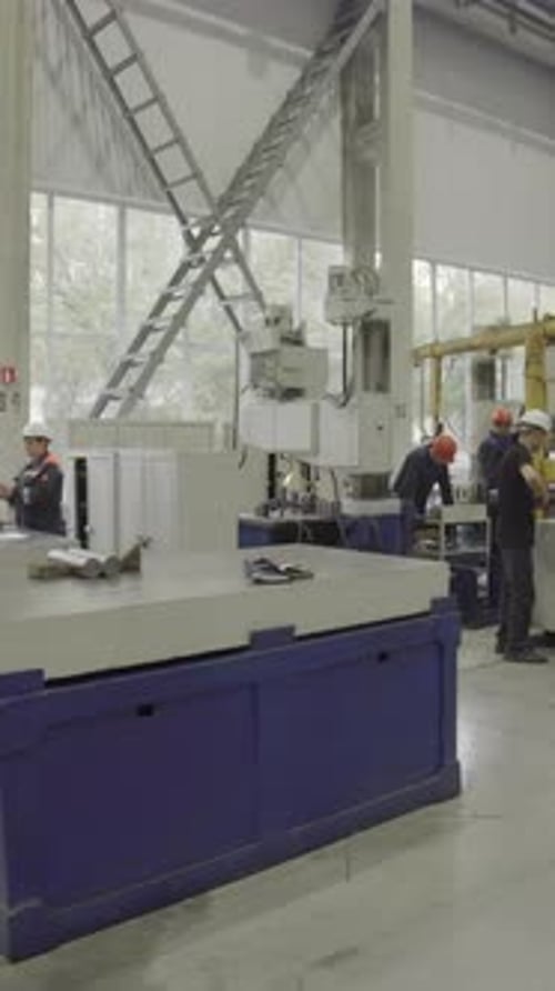 Factory Workers Assembling Industrial Parts on a Machine Stock Clip
