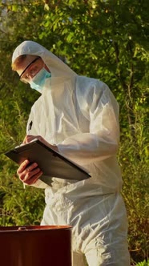 Inspector Examining Plants and Barrel During Field Inspection