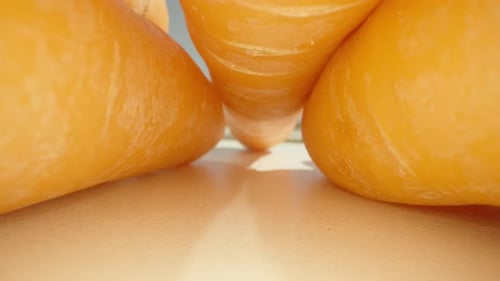 raw fresh carrots on a white table, the camera passes under the carrot. Dolly slider extreme close-u