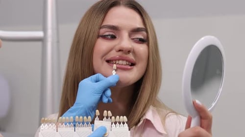 Woman Matching Teeth Implants in Dental Office