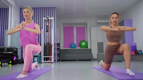 Female Instructor Leading Leg Stretch Exercise in Gym