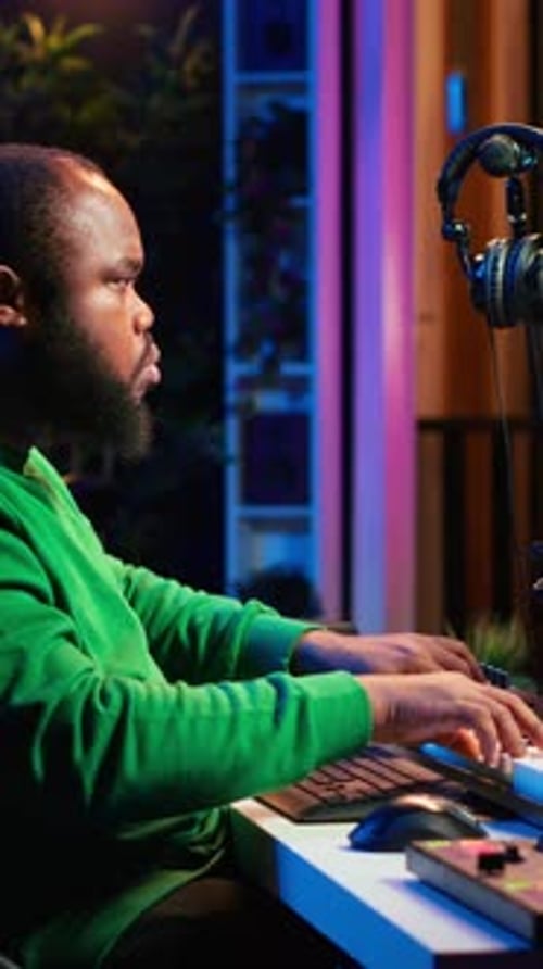Adult Man Plays Keyboard in Home Studio