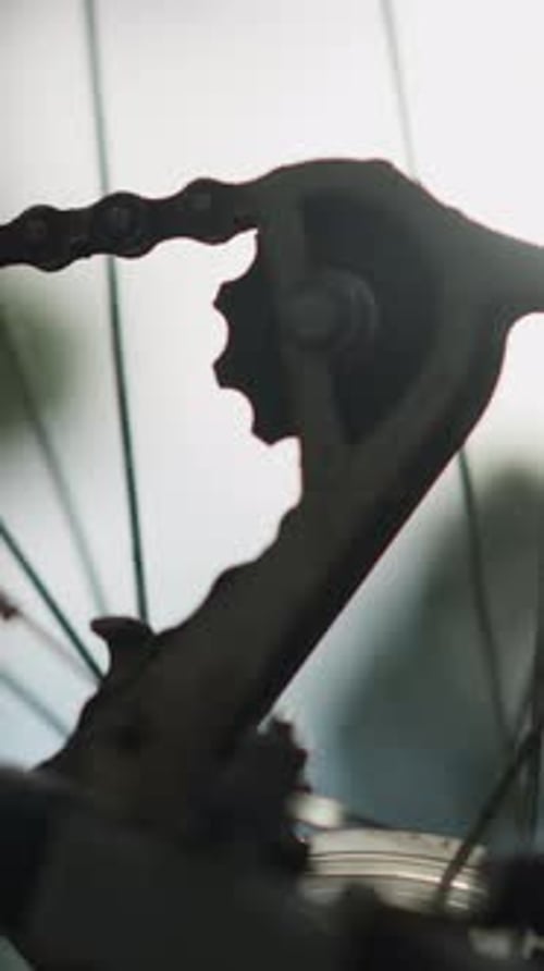 CloseUp of Bicycle Chain and Gear System Rotating Slowly in Sunlight