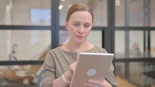 Woman Working on a Tablet in Office Setting